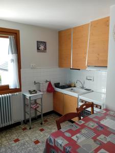 een keuken met houten kasten, een wastafel en een tafel bij appartement thones in Thônes