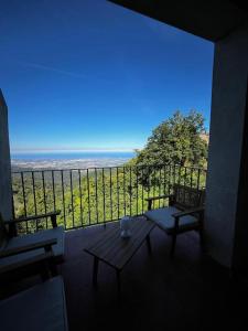 einen Balkon mit einer Bank und Meerblick in der Unterkunft Gîtes la fontaine corse vue panoramique in Loreto-di-Casinca