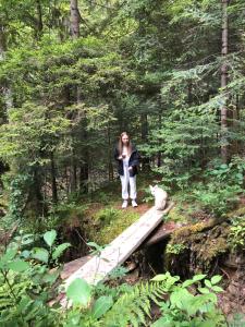 a woman standing on a bridge in the woods at Котедж GW in Guta