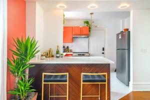 an orange and white kitchen with orange cabinets at Jungle House Luxury Homes - Columbus Downtown Short North - Steps to Convention Center & Nationwide Arena - Sleeps up to 8 - Free Parking - Over 5,800 Five Stars in Columbus +56 photos