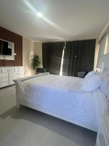 una camera da letto con un grande letto bianco in una stanza di Villa Medrano  Altre 19 foto