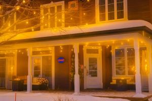 モントランブランにあるLe 900 Tremblant Inn Café and Bistroの雪とライトが飾られた家の玄関ポーチ
