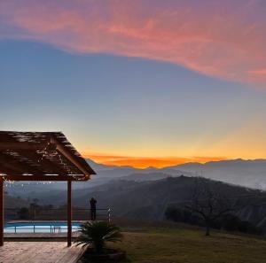 a person standing next to a swimming pool at sunset at Casa Amrita B&B in Teramo