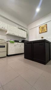 eine große Küche mit weißen Schränken und einem Herd in der Unterkunft Torreón Jardin apartment near IMSS clinics 16 and 71 in Torreón