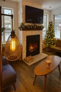 モントランブランにあるLe 900 Tremblant Inn Café and Bistroのクリスマスツリーと暖炉のあるリビングルーム
