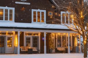 a restaurant in the snow in front of a building at Le 900 Tremblant Inn Café and Bistro in Mont-Tremblant