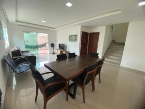 a dining room with a wooden table and chairs at Requinte e Conforto em Guarapari in Guarapari