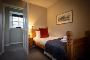 een kleine slaapkamer met een bed en een raam bij Dunvegan Castle Laundry Cottage in Dunvegan