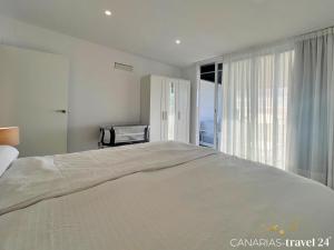 a large white bed in a bedroom with a window at Los Roquitos II in El Paso