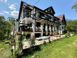 una casa con molte piante davanti di MURMUR Chalet a Valea Tîrsei