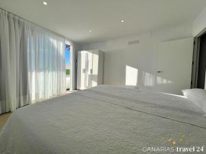 a large bed in a room with a large window at Los Roquitos II in El Paso