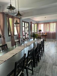 a large dining room with a long table and chairs at MURMUR Chalet in Valea Tîrsei