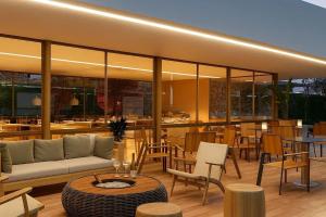a patio with a couch and chairs and tables at Beach Class Summer Residence in Porto De Galinhas