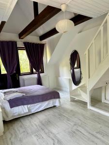 una camera con un grande letto e tende viola di MURMUR Chalet a Valea Tîrsei