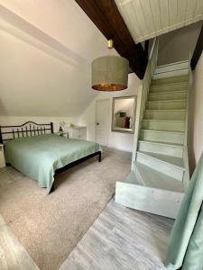 una camera con letto, scala e lampadario pendente di MURMUR Chalet a Valea Tîrsei