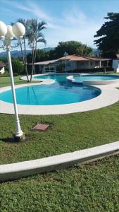 an empty swimming pool with a light pole in the grass at Las Lajas Chalet Sweet home 2 bedrooms in Las Lajas
