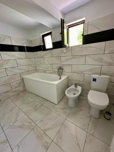 un bagno bianco con vasca e WC di MURMUR Chalet a Valea Tîrsei Altre 24 foto