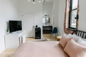a white bedroom with a bed and a tv at Hotel Royal in Toledo