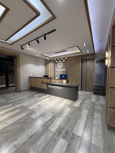 an office lobby with a reception desk and wooden floors at Afsona in Qarshi