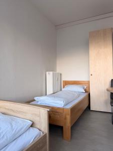 twee eenpersoonsbedden in een kamer met een scheidingswand bij Haus an der Brücke in München