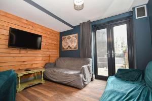 a living room with a couch and a flat screen tv at 4 Private Rooms in Shared Apartment with Kitchen in Leeds