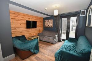 a living room with two couches and a flat screen tv at 4 Private Rooms in Shared Apartment with Kitchen in Leeds +7 photos