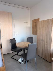 een kamer met een tafel en stoelen en een kast bij Haus an der Brücke in München