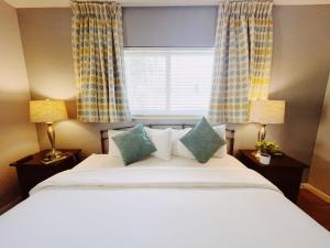 a bedroom with a bed with two lamps and a window at Great Escape Apartments By Lowkl in Fort Lauderdale