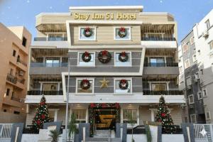 a building with christmas wreaths on the windows at Stay Inn 51 Hotel in Sheikh Zayed