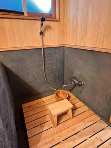 bagno con doccia e pavimento in legno di うご八かやぶ㐂 a Narazaki
