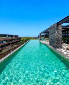 een zwembad met water voor een gebouw bij The Empire Amira in Tulum