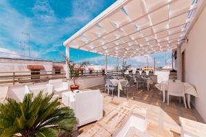 a patio with tables and chairs on a balcony at LORY'S HOUSE in Porto Cesareo