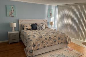 a bedroom with a bed with a comforter and pillows at Van Lee 1003 - Oceanview Beach Condo in Ormond Beach