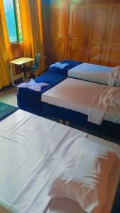 three beds in a room with a table and a chair at Colibri Hostel in Armenia