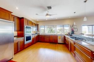 een grote keuken met houten kasten en een plafondventilator bij NSB Indian River Waterfront Gem in Cedar Island