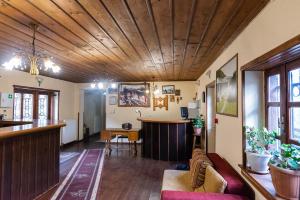 a living room with a wooden ceiling and a bar at Manis Hotel in Nymfaio
