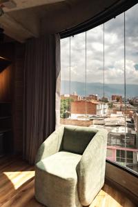 a living room with a couch and a large window at Uukam by Bernalo Hotels in Medellín