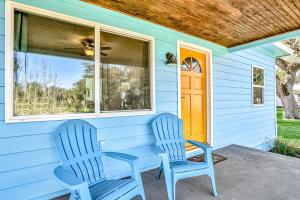 twee blauwe stoelen op de veranda van een huis bij Edgewater- River Cottage in Edgewater
