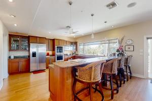 een keuken met een groot eiland met barkrukken bij NSB Indian River Waterfront Gem in Cedar Island