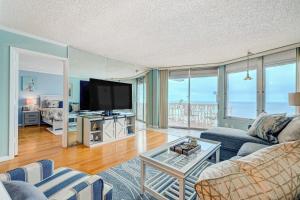 a living room with a couch and a tv at Van Lee 1003 - Oceanview Beach Condo in Ormond Beach