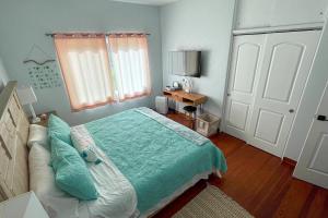 een slaapkamer met een bed met een groen dekbed bij Edgewater- River Cottage in Edgewater