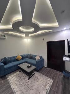 un soggiorno con un divano blu e una TV di Dar Alfakhama ad Al-Bāha