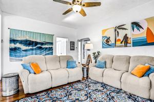 een woonkamer met twee banken en een plafondventilator bij Edgewater- River Cottage in Edgewater +22 foto's