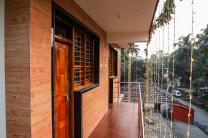 a room with a door and a balcony with a view at Annu Mane Homestay in Gokarna