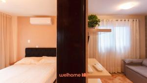 Un dormitorio con una cama, una mesa y un sofá. en Apartamento em Londrina no Centro da cidade, en Londrina