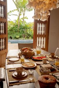 een tafel met eten en drinken erop bij Casa Teçá in Guriú