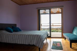 a bedroom with a bed and a window and a chair at Cabañas Isla del Mar in Constitución +11 photos
