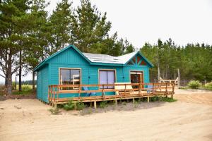 a blue house with a porch on a beach at Cabañas Isla del Mar in Constitución