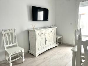 a white cabinet and a chair in a room at Señorón & Requesón in Olivenza