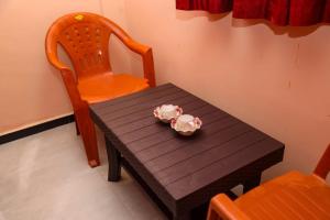 a wooden table with two cups on top of it at Annu Mane Homestay in Gokarna